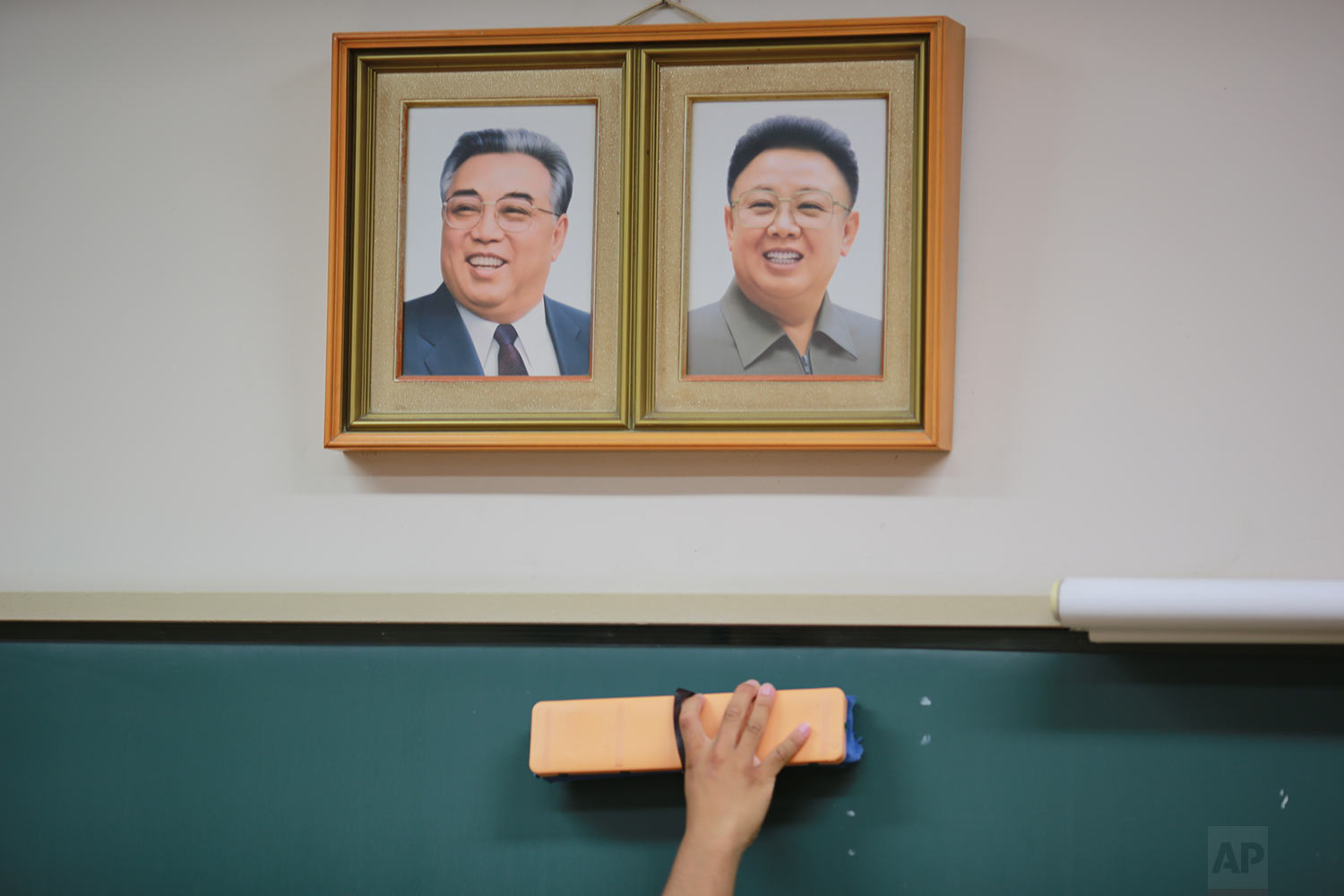  In this Sept. 26, 2017 photo, a student cleans the blackboard under the portraits of the late North Korean leaders Kim Il Sung and Kim Jong Il hanging on the classroom wall at a Tokyo Korean high school in Tokyo. (AP Photo/Eugene Hoshiko) 