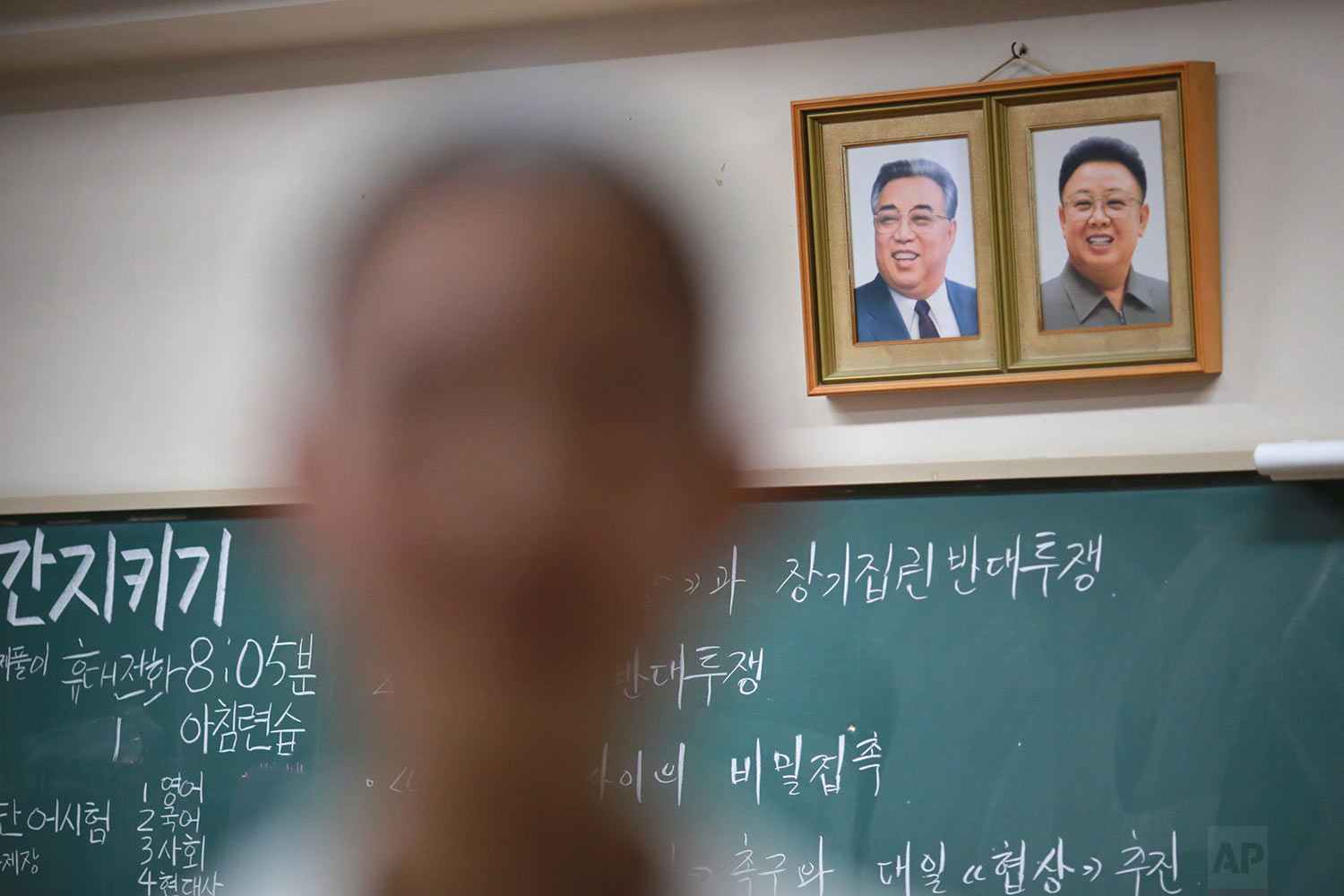  In this Sept. 26, 2017, photo, a student stands near the portraits of the late North Korean leaders Kim Il Sung and Kim Jong Il hanging on a classroom wall in a Korean high school in Tokyo. Many third- and fourth-generation descendants of Koreans br