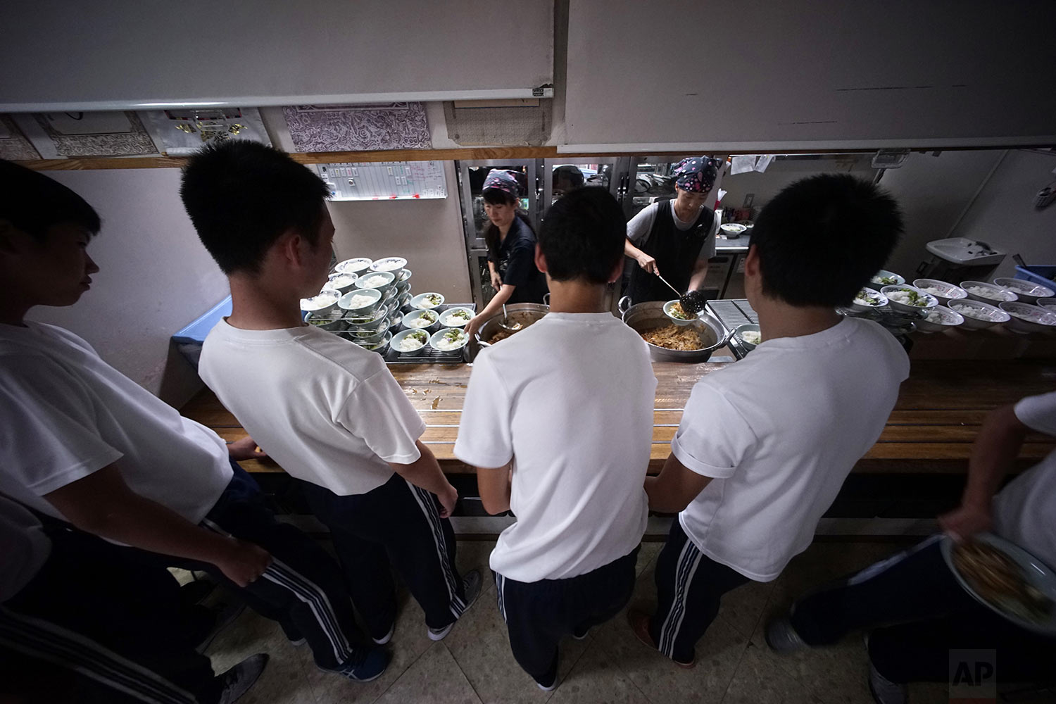  In this Sept. 26, 2017, photo, students line up for lunch at a dining hall in a Korean high school in Tokyo. (AP Photo/Eugene Hoshiko) 
