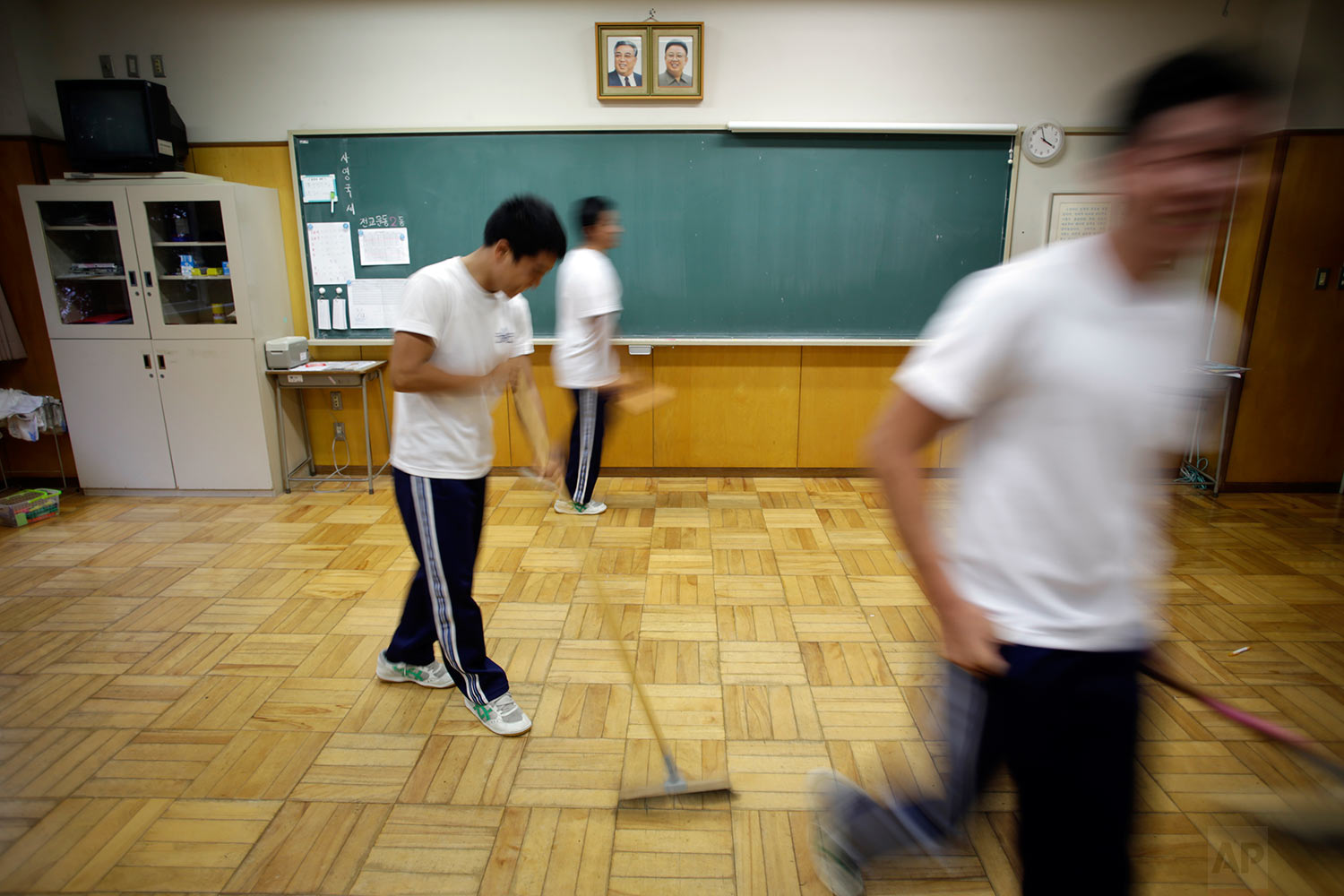  In this Sept. 26, 2017, photo, students clean their classroom under portraits of the late North Korean leaders Kim Il Sung and Kim Jong Il at a Korean high school in Tokyo. (AP Photo/Eugene Hoshiko) 