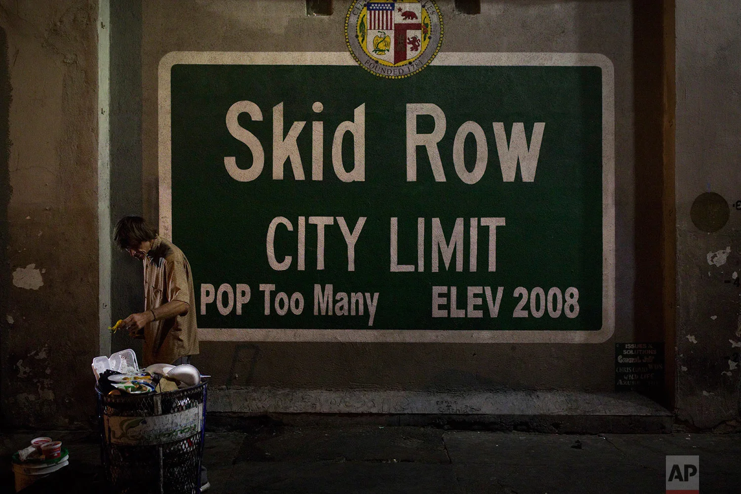 A homeless man takes food from a trash can in Los Angeles' Skid Row area, home to the nation's largest concentration of homeless people, Saturday, Oct. 28, 2017, in Los Angeles. At least 10 cities have declared official states of emergency, and California declared a statewide emergency due to a hepatitis A outbreak linked to homeless encampments. Comparisons are being made to conditions more commonly seen in Third World countries. (AP Photo/Jae C. Hong)