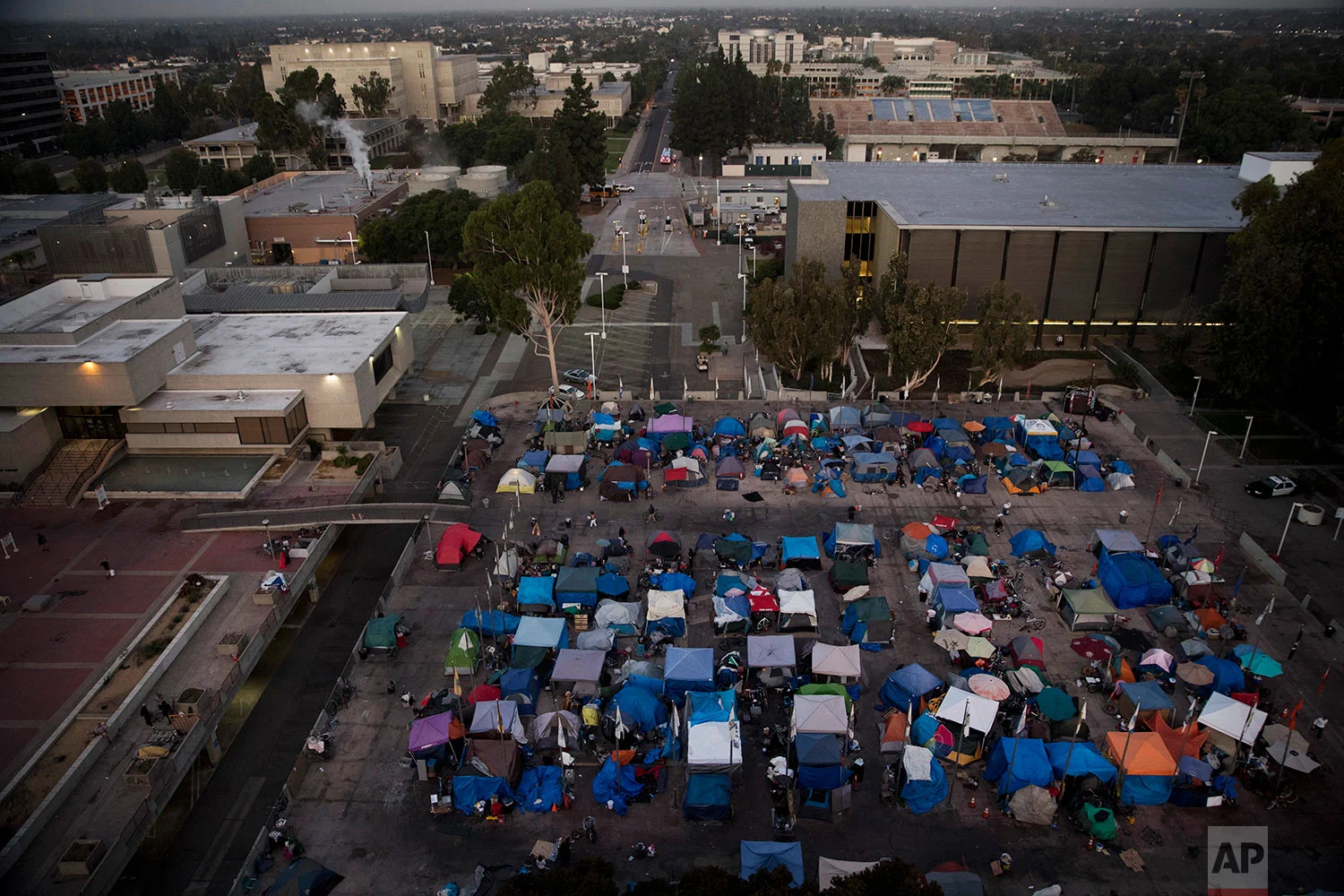 A large homeless encampment is formed on the "Plaza of the Flags" elevated park at the Santa Ana Civic Center complex Wednesday, Oct. 11, 2017, in Santa Ana, Calif. California declared a statewide emergency due to a hepatitis A outbreak linked to homeless encampments. Comparisons are being made to conditions more commonly seen in Third World countries. (AP Photo/Jae C. Hong)