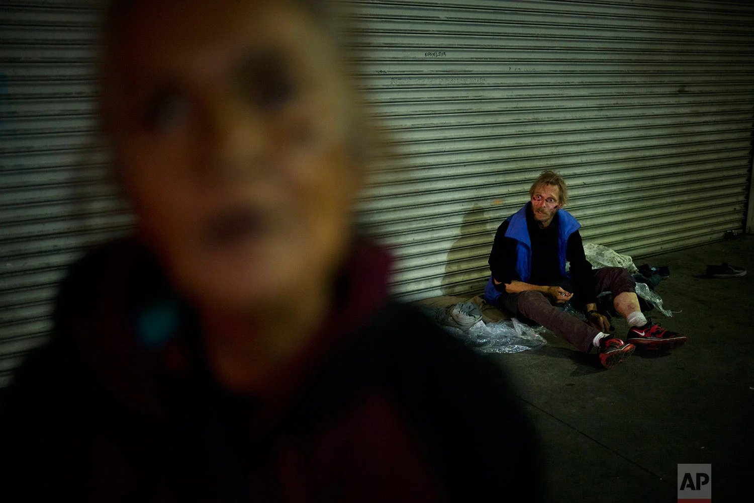A mentally disabled woman stares at a camera as a homeless drug addict, who said his name was April Jane, sits on a sidewalk asking for money, Thursday, Nov. 2, 2017, in downtown Los Angeles. The latest nationwide homeless count shows that 4 of every 10 people living on the street are severely mentally ill or have a serious drug addiction. (AP Photo/Jae C. Hong)