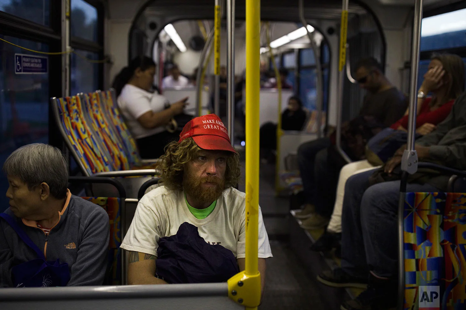 Wearing a "Make America Great Again" hat, Nathanael Baisley, 38, sits in a bus in Los Angeles en route to Santa Monica Beach, where he spends the night, Saturday, Oct. 28, 2017. Baisley said he has been homeless on and off for three years and is going through a divorce with his wife who lives in England with their 5-year-old son. (AP Photo/Jae C. Hong)