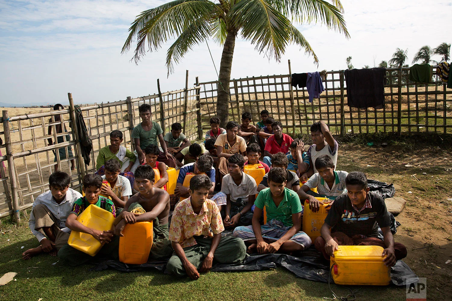 In this Nov. 4, 2017, photo, newly arrived Rohingya Muslims with yellow plastic drums they used to aid flotation while crossing the Naf river wait in Shah Porir Dwip to be transferred to a refugee camp in Cox's Bazar, Bangladesh. (AP Photo/Bernat Armangue)
