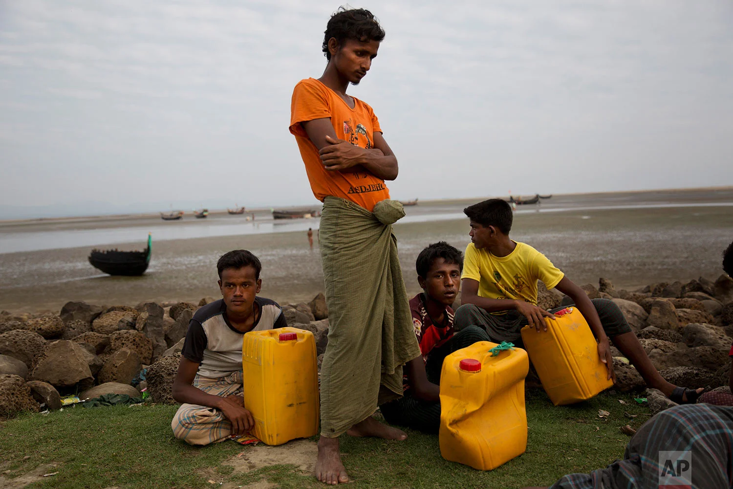 In this Nov. 5, 2017, photo, newly arrived Rohingya Muslim Aman Ullah, 18, left, Abdul Karim, 19, second left, Mohammed Sadek, 14, third left and Robiul Hassan, 15, right, wait in Shah Porir Dwip, Bangladesh to be transferred to a refugee camp in Cox's Bazar, Bangladesh. (AP Photo/Bernat Armangue)