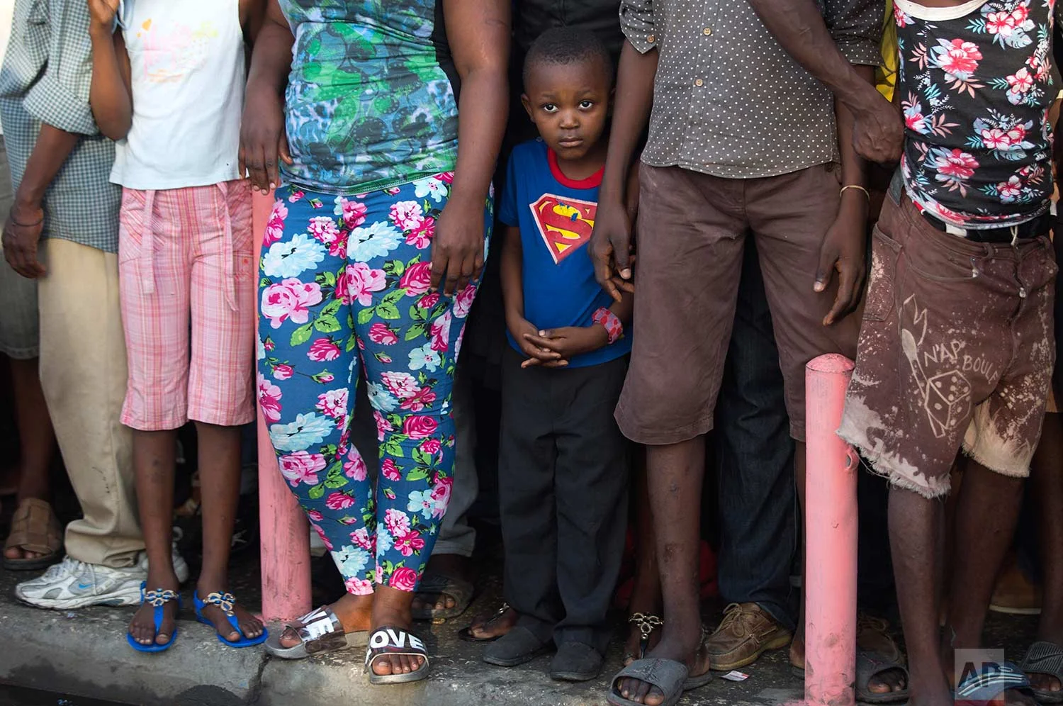 A boy wearing a Superman T-shirt stands with a group of grownups watching a ceremony marking the 211th anniversary of the assassination of independence hero Gen. Jean-Jacques Dessalines, in Port-au-Prince, Haiti, Tuesday Oct. 17, 2017. (AP Photo/Dieu Nalio Chery)