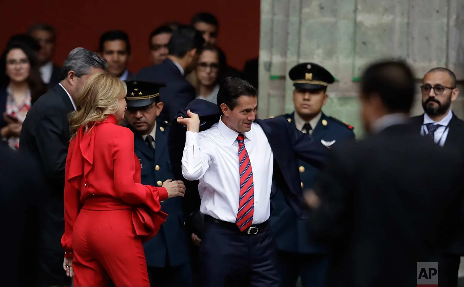 Mexican President Enrique Pena Nieto puts on his jacket as his wife Angelica Rivera looks on before welcoming Canadian Prime Minister Justin Trudeau and his wife Sophie Gregoire Trudeau to the National Palace in Mexico City, Thursday, Oct. 12, 2017. (AP Photo/Rebecca Blackwell)
