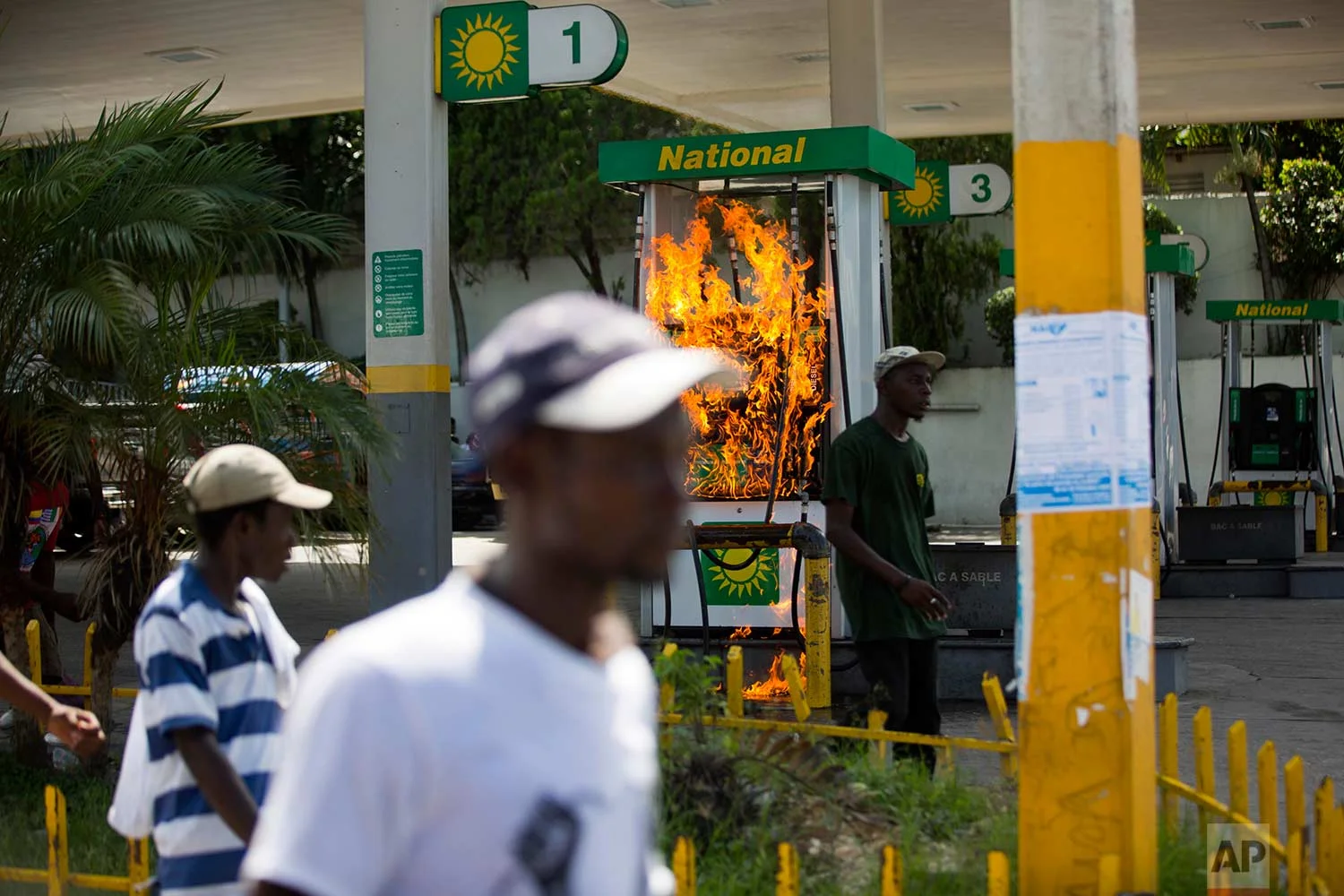 A gas pump set on fire by protesters goes up in flames during a protest against government tax hikes in Port-au-Prince, Haiti, Tuesday, Oct. 17, 2017. (AP Photo/Dieu Nalio Chery)