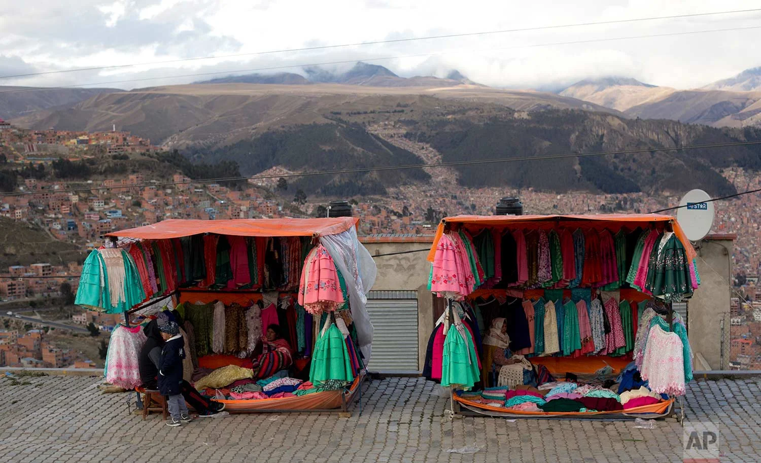 Traditional Andean women's skirts hang for sale at vendors' stores set up along the road between El Alto and La Paz, Bolivia, Thursday, Oct. 12, 2017. (AP Photo/Juan Karita)