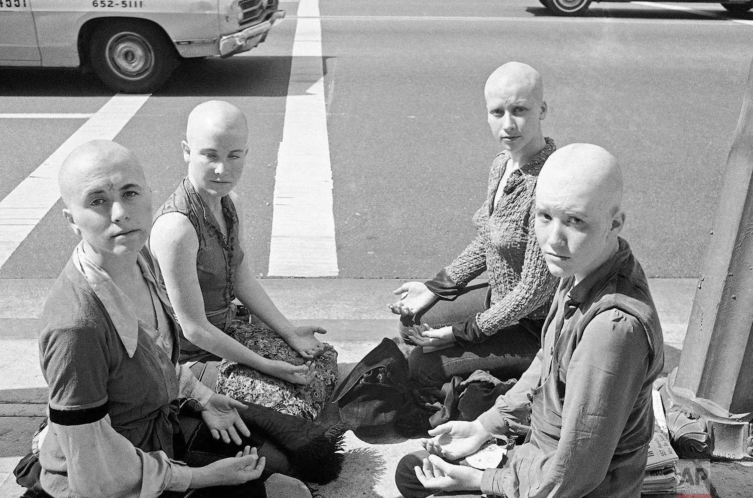 Four young women members of the Charles Manson "family" kneel on the sidewalk outside the Los Angeles at Hall of Justice, March 29, 1971 with their heads shaved. They've kept a vigil at the building throughout the long trial in which Manson and three other women were convicted of slaying actress Sharon Tate and six others. Left to right: Cathy Gillies, Kitty Lutesinger, Sandy Good, Brenda McCann. Jurors were believed near a verdict on the penalty to be imposed on the defendants. (AP Photo/Wally Fong)