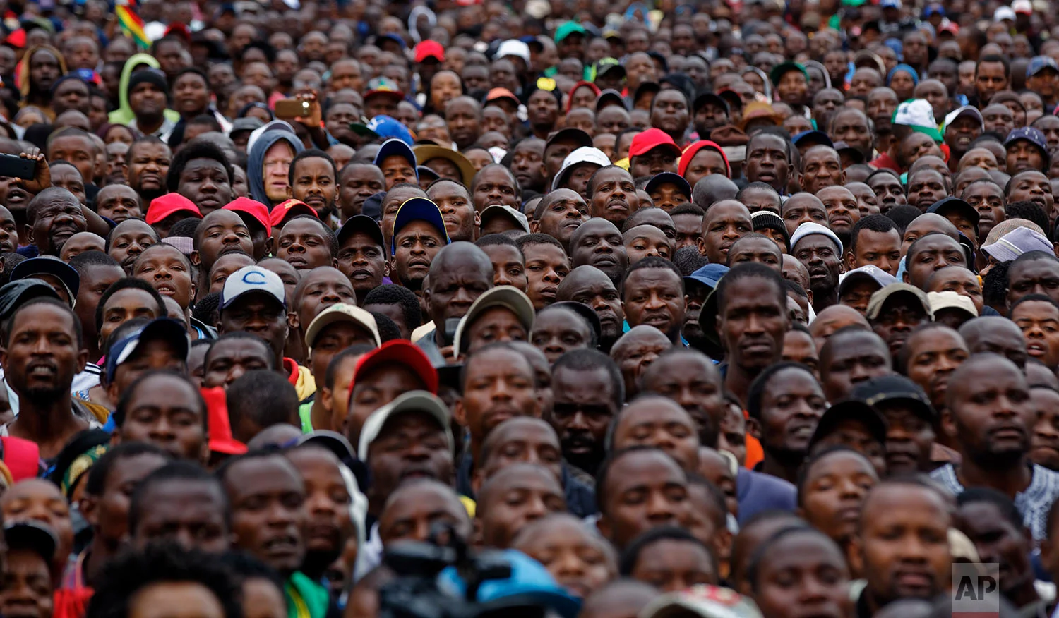 Protesters gather at a demonstration of tens of thousands at Zimbabwe Grounds in Harare, Zimbabwe Saturday, Nov. 18, 2017. Opponents of Mugabe are demonstrating for the ouster of the 93-year-old leader who is virtually powerless and deserted by most of his allies. (AP Photo/Ben Curtis)