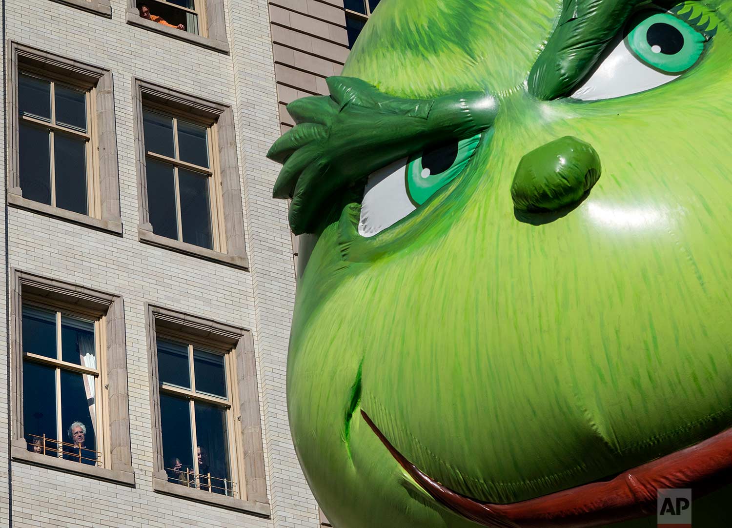  The Grinch balloon passes by windows of a building on Central Park West during Macy's Thanksgiving Day Parade in New York Thursday, Nov. 23, 2017. (AP Photo/Craig Ruttle) 