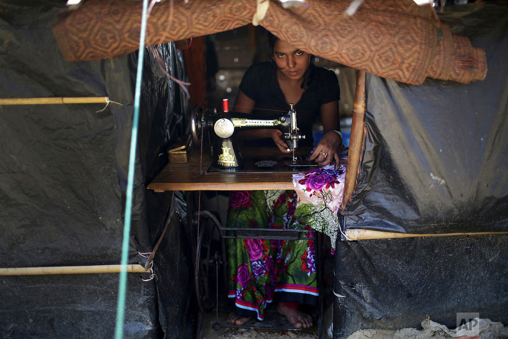  A Rohingya Muslim woman works on her sewing machine inside her tent at Kutupalong refugee camp on Tuesday, Nov. 28, 2017, in Bangladesh. Since late August, more than 620,000 Rohingya have fled Myanmar's Rakhine state into neighboring Bangladesh, whe