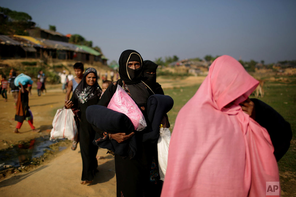  Rohingya Muslim women carry blankets and other supplies they collected from aid distribution centers in Kutupalong refugee camp in Bangladesh, Tuesday, Nov. 21, 2017. Since late August, more than 620,000 Rohingya have fled Myanmar's Rakhine state in