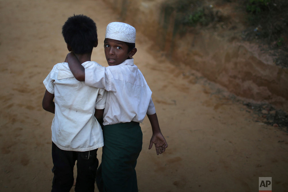  A Rohingya Muslim boy looks back as he walks with his friend in Kutupalong refugee camp on Saturday, Nov. 25, 2017, in Bangladesh.  The United Nations and others have said the military's actions appeared to be a campaign of "ethnic cleansing," using