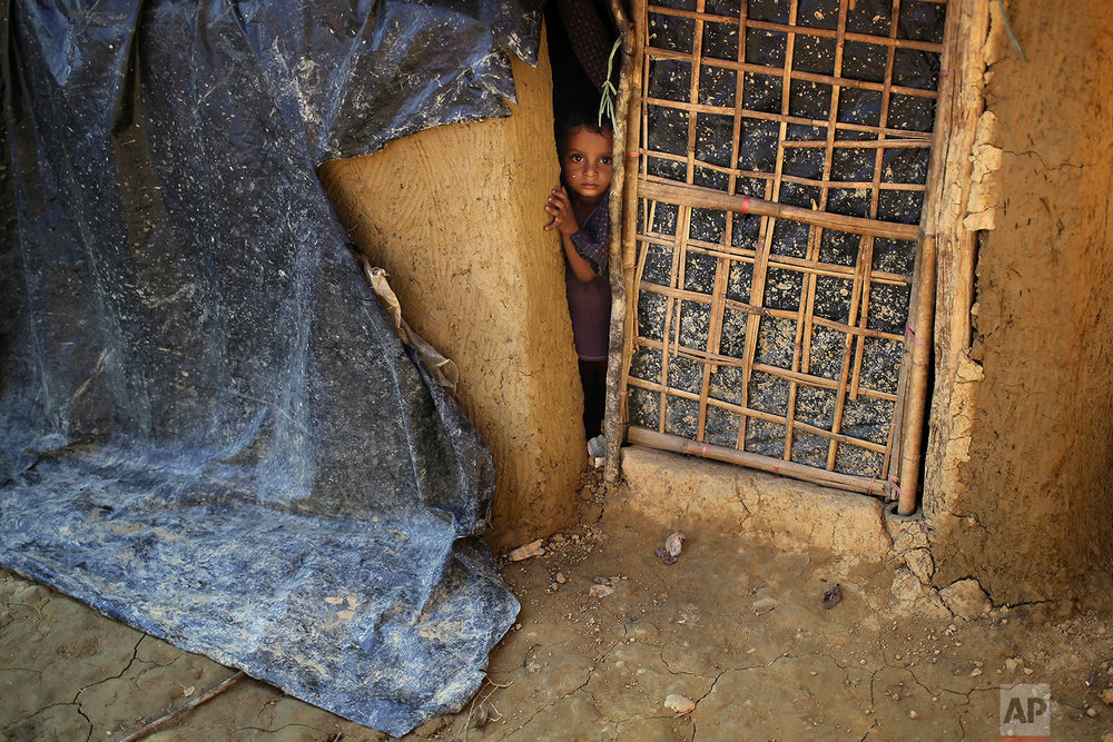  A Rohingya Muslim child peeks out of his family's home made from mud on Tuesday, Nov. 21, 2017, in Kutupalong refugee camp in Bangladesh. Since late August, more than 620,000 Rohingya have fled Myanmar's Rakhine state into neighboring Bangladesh, se