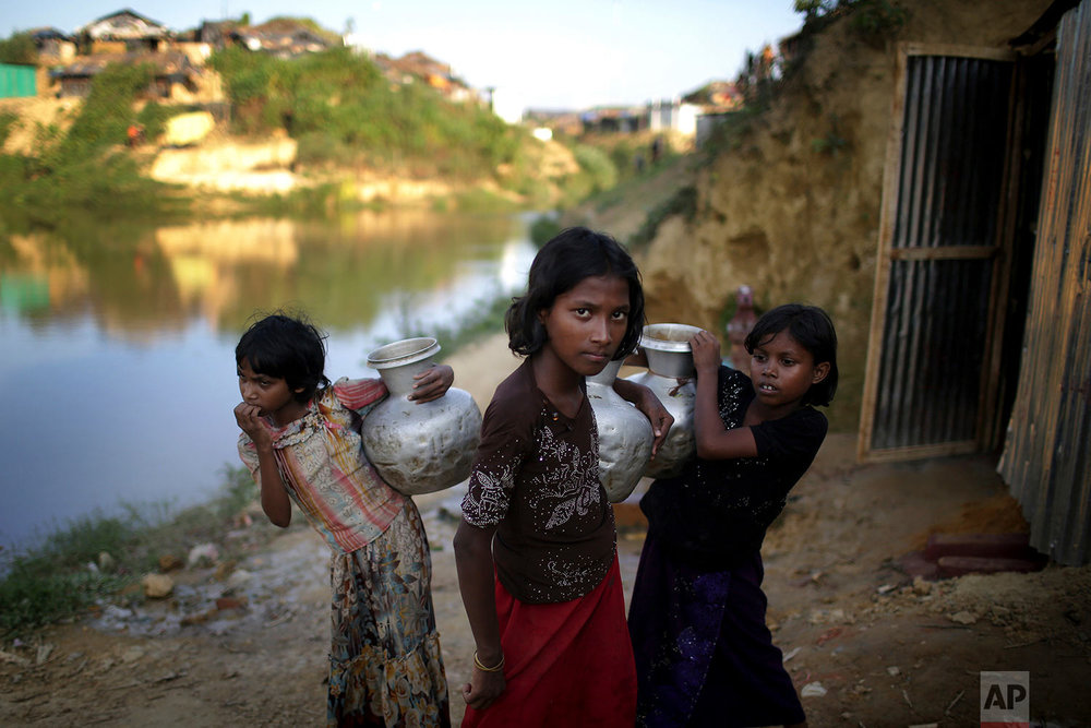  In this Sunday, Nov. 19, 2017, photo, Rohingya Muslim girls carry water pots in Kutupalong refugee camp in Bangladesh.  More than 620,000 Rohingya have fled Rakhine for neighbouring Bangladesh since late August 2017, when the military launched what 
