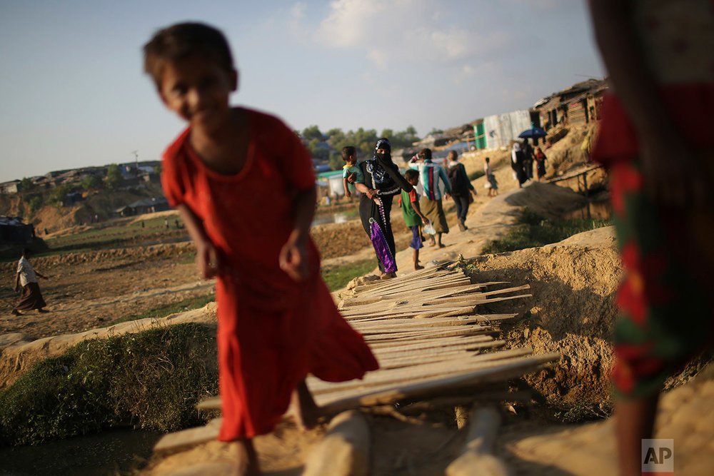  In this Sunday, Nov. 19, 2017, photo, Rohingya Muslims cross a wooden bridge as they make their way through Kutupalong refugee camp in Bangladesh. More than 620,000 Rohingya have fled Rakhine for neighbouring Bangladesh since late August 2017, when 