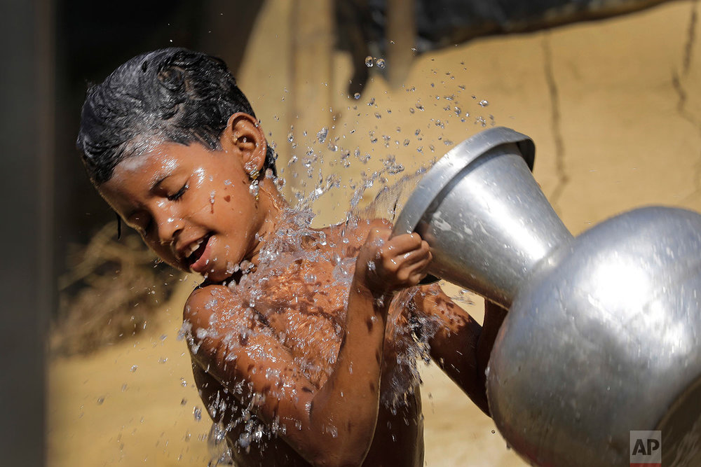  A Rohingya Muslim pours water on herself as she bathes outside her tent in Kutupalong Refugee camp on Monday, Nov. 20, 2017, in Bangladesh. More than 620,000 Rohingya have fled Rakhine for neighboring Bangladesh since late August, when the military 