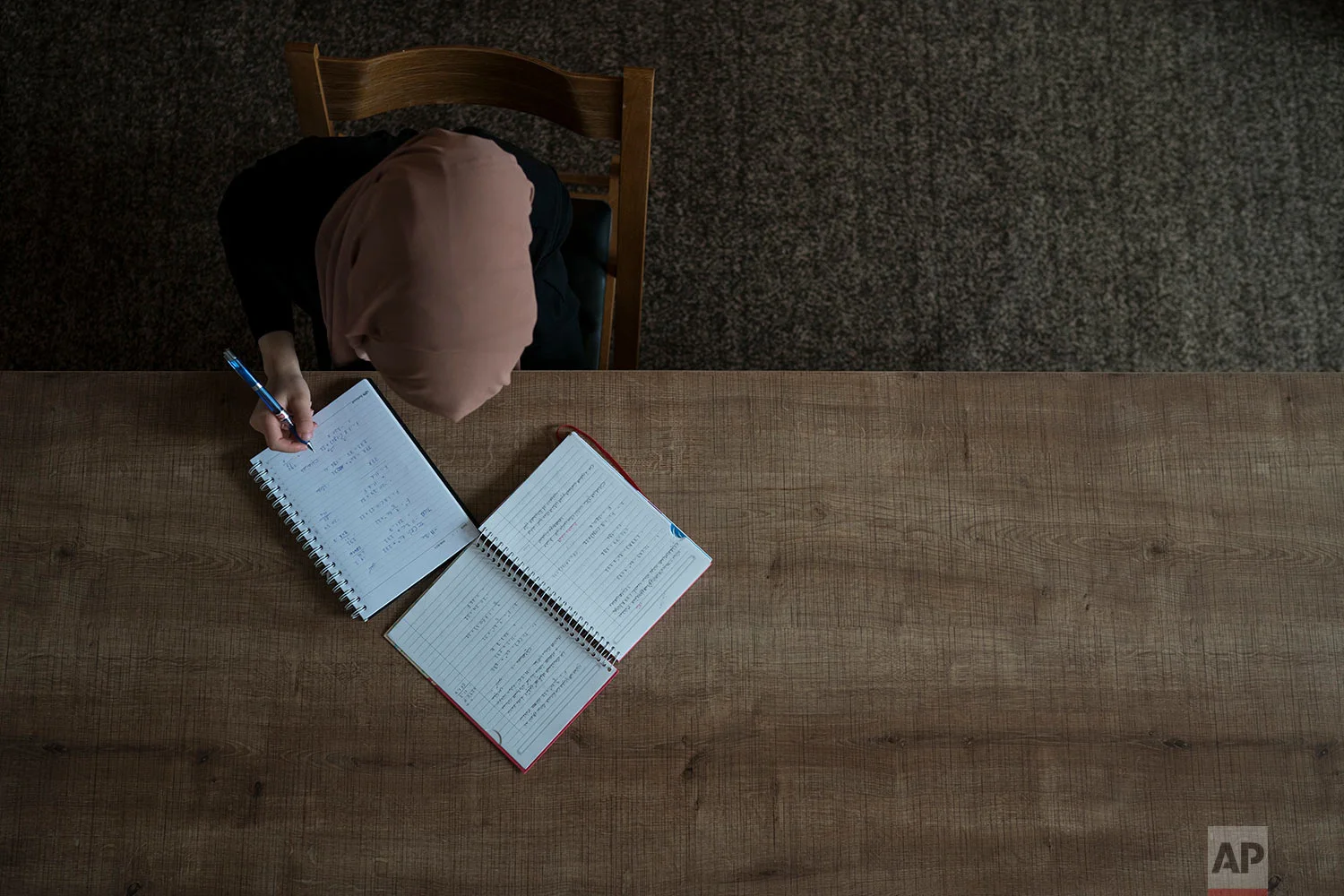 Ferah studies for an exam in Irbil, Iraq, in this photo taken Nov. 11, 2017. Before the Islamic State group took over her home city of Mosul in 2014, Ferah had just started at a new private school that she loved, with all new friends. After the takeover, she stopped going to school, her friends fled, and the teenager fell deeper into isolation and despair. (AP Photo/Felipe Dana)