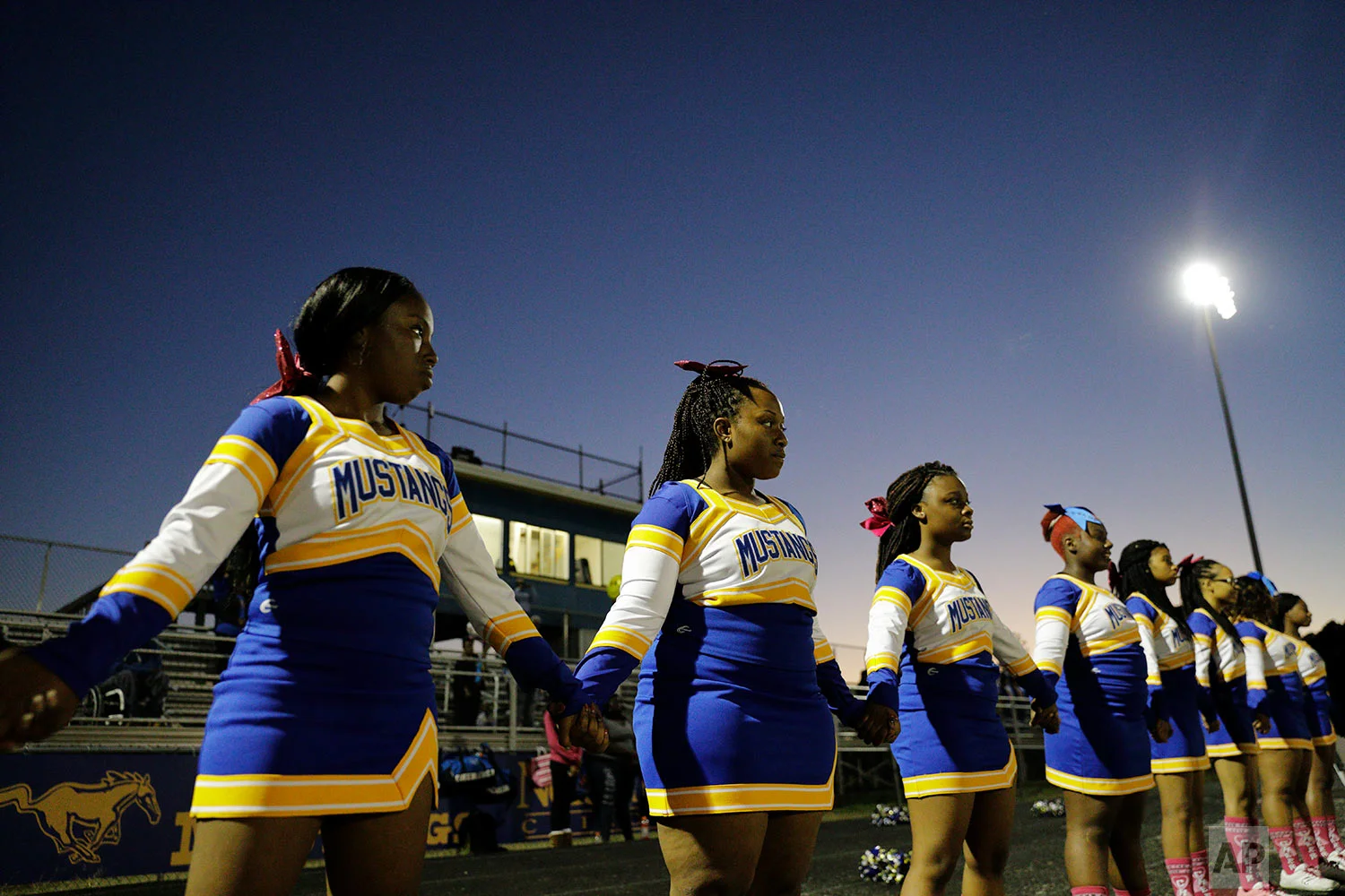 South Robeson High School cheerleaders join hands during the national anthem before a football game in Rowland, N.C., Friday, Oct. 27, 2017. (AP Photo/David Goldman)
