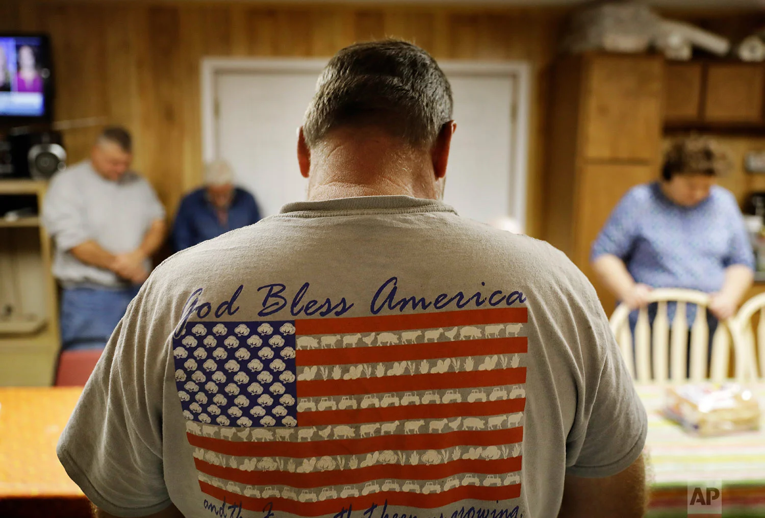 Dinner guests bow their heads in prayer before their weekly gathering at a home in Lumberton, N.C. (AP Photo/David Goldman)