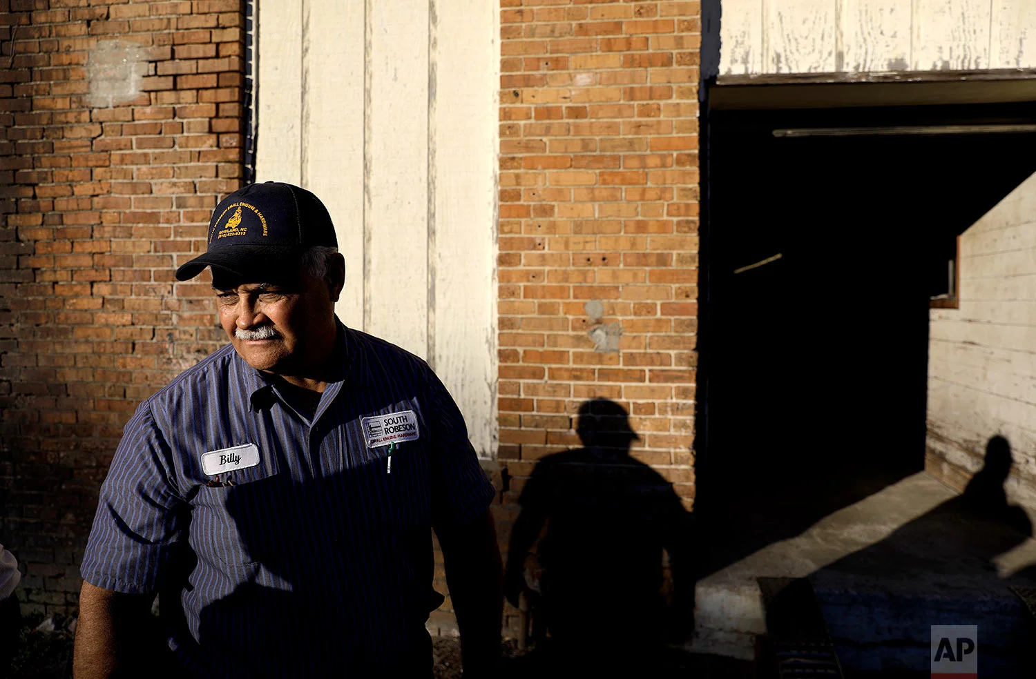 Billy Hunt, a Native American and a Marine, stands outside his small engine repair shop in Rowland, N.C., Thursday, Oct. 26, 2017. Hunt was hurt, because he thinks the cheerleaders who knelt during the national anthem failed to consider people like him - people who served their country and see the flag as a symbol of that service, of loved ones and limbs lost to war. It seemed to him, like many others here, that they'd chosen a side, without imagining life on the other one. "I'd like to see it back to people start feeling for each other again," he said, "instead of - 'it's my idea, it's great, if it's your idea, it sucks.'" (AP Photo/David Goldman)