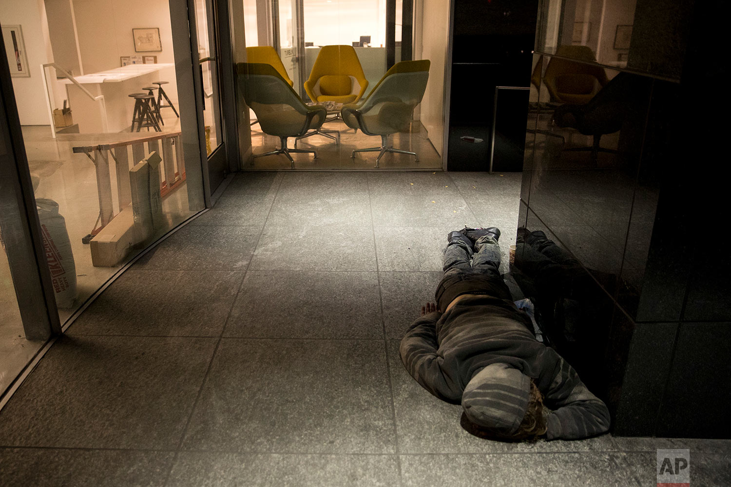  A homeless man sleeps on a concrete floor outside an office building under renovation Friday, Dec. 1, 2017, in Los Angeles. The U.S. Department on Housing and Urban Development release of the 2017 homeless numbers are expected to show a dramatic inc