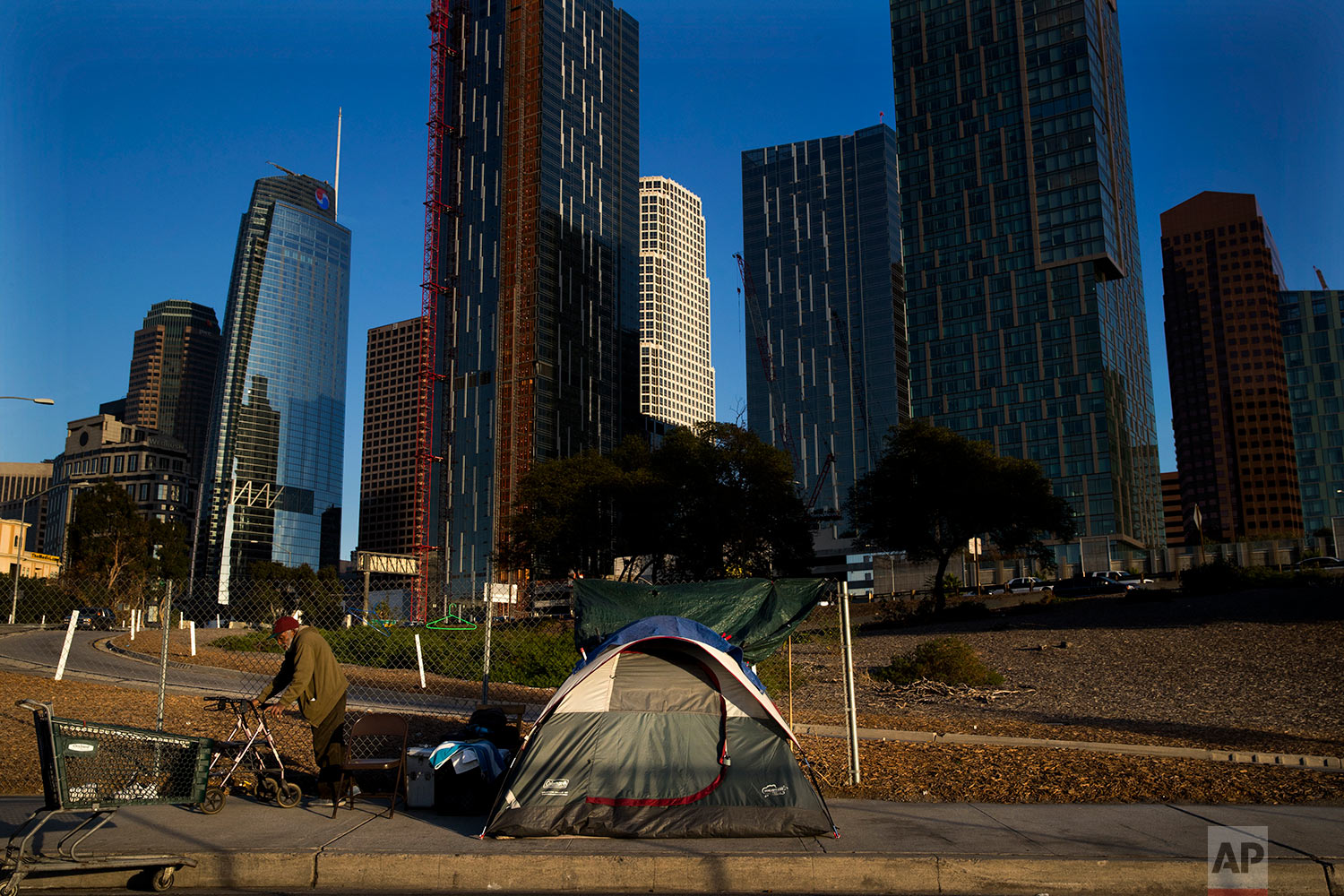  A homeless man, who declined to give his name, is dwarfed by skyscrapers Monday, Dec. 4, 2017, in Los Angeles. The U.S. Department on Housing and Urban Development release of the 2017 homeless numbers are expected to show a dramatic increase in the 