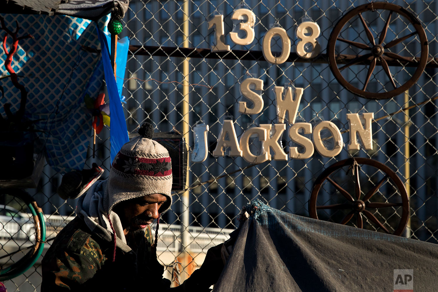  Thaddeus Bell, 50, who is homeless, sits outside his tent with the street address of his childhood home in Oklahoma hanging on a fence Monday, Dec. 4, 2017, in Los Angeles. "I might be homeless but I'm human just like everybody else," said Bell. "I 