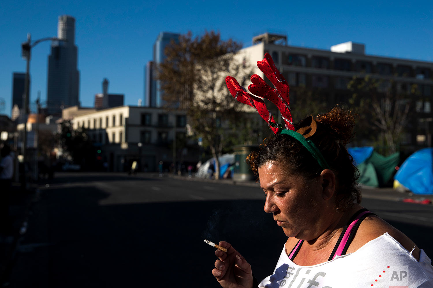  Wearing a Christmas headband, Grace Fernandez, who is homeless, smokes outside her tent in the Skid Row area of downtown Los Angeles, Friday, Dec. 1, 2017. "Holidays are just so much special. It should bring us altogether as one even if we are homel