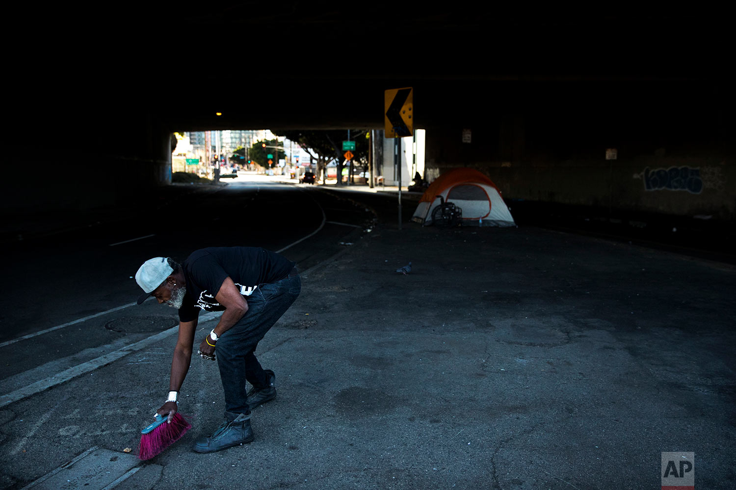  Thurman Butler Jr., 66, who is homeless, sweeps around his tent Friday, Dec. 1, 2017, in Los Angeles. "A lot of people in America don't realize they might be two checks, three checks, four checks away from being homeless," said Butler who became hom