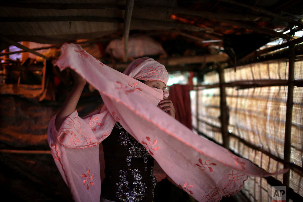  &nbsp;In this Sunday, Nov. 19, 2017, photo, R, 13, who says she was raped by members of Myanmar's armed forces in late August, adjusts her headscarf while photographed in her family's tent in Kutupalong refugee camp in Bangladesh. (AP Photo/Wong May