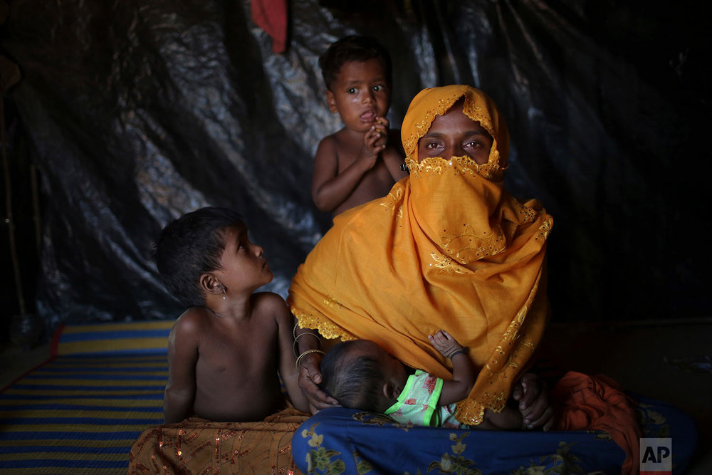  In this Sunday, Nov. 19, 2017, photo, K, 25, mother of six, who says she was raped by members of Myanmar's armed forces in late August, is photographed as she nurses her baby with her two children beside her in their tent in Kutupalong refugee camp 