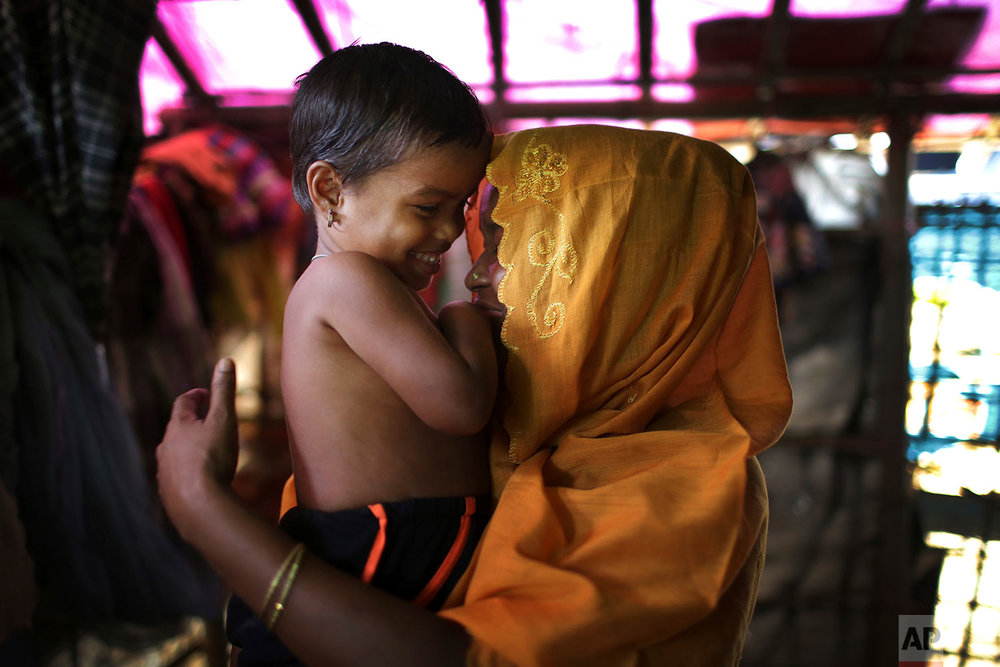  In this Wednesday, Nov. 22, 2017, photo, R, 28, mother of six, who says she was raped by members of Myanmar's armed forces in late August, caresses her daughter while being photographed in her tent in Kutupalong refugee camp in Bangladesh.  (AP Phot