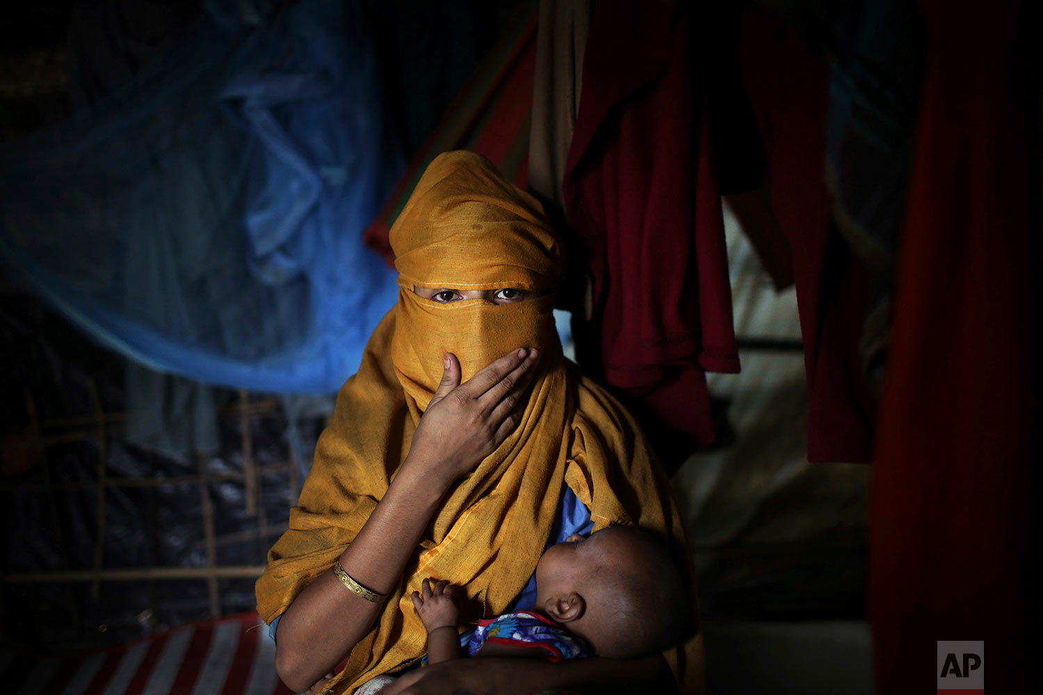  In this Wednesday, Nov. 22, 2017, photo, S, 16, mother of baby boy, who says she was raped by members of Myanmar's armed forces in early August carries her baby while being photographed in her tent in Kutupalong refugee camp in Bangladesh.  (AP Phot