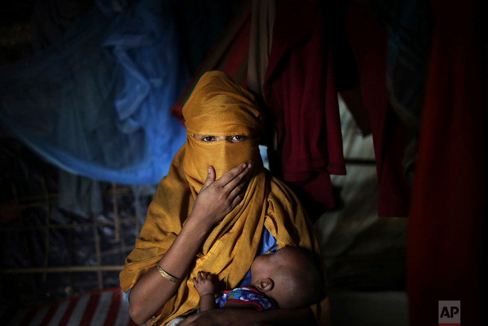  In this Wednesday, Nov. 22, 2017, photo, S, 16, mother of baby boy, who says she was raped by members of Myanmar's armed forces in early August carries her baby while being photographed in her tent in Kutupalong refugee camp in Bangladesh.  (AP Phot