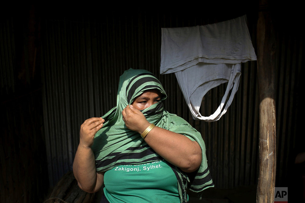  In this Wednesday, Nov. 22, 2017, photo, N, 31, mother of girl, who says she was raped by members of Myanmar's armed forces in late August, adjusts her headscarf as she is photographed outside her home in Kutupalong refugee camp in Bangladesh.  (AP 