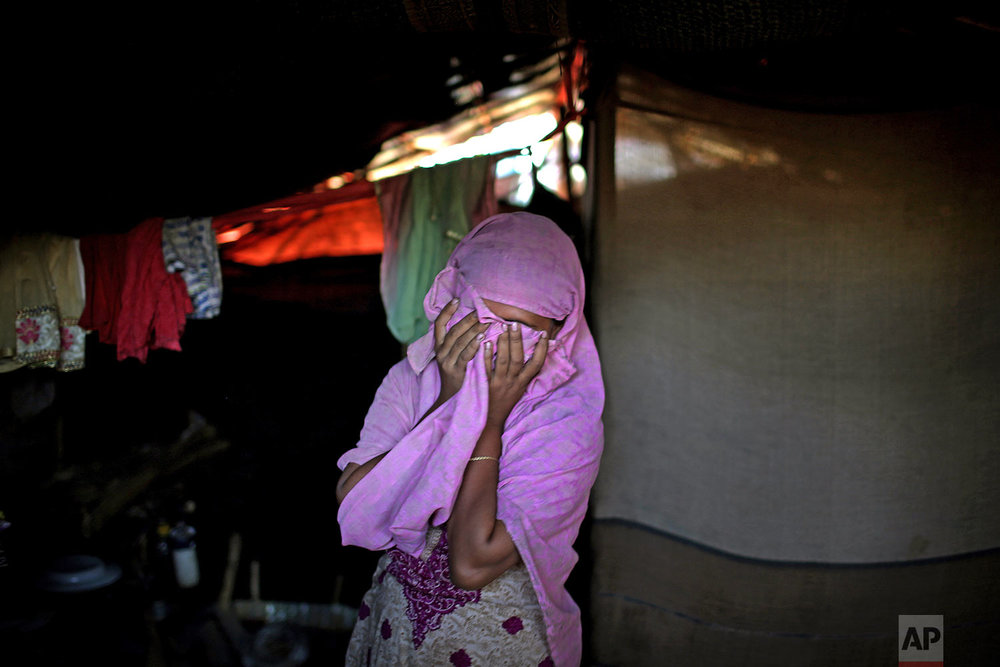  In this Monday, Nov. 20, 2017, photo, A, 20, mother of one, who says she was raped by members of Myanmar's armed forces in late August, covers her face while being photographed in her tent in Kutupalong refugee camp in Bangladesh.  (AP Photo/Wong Ma