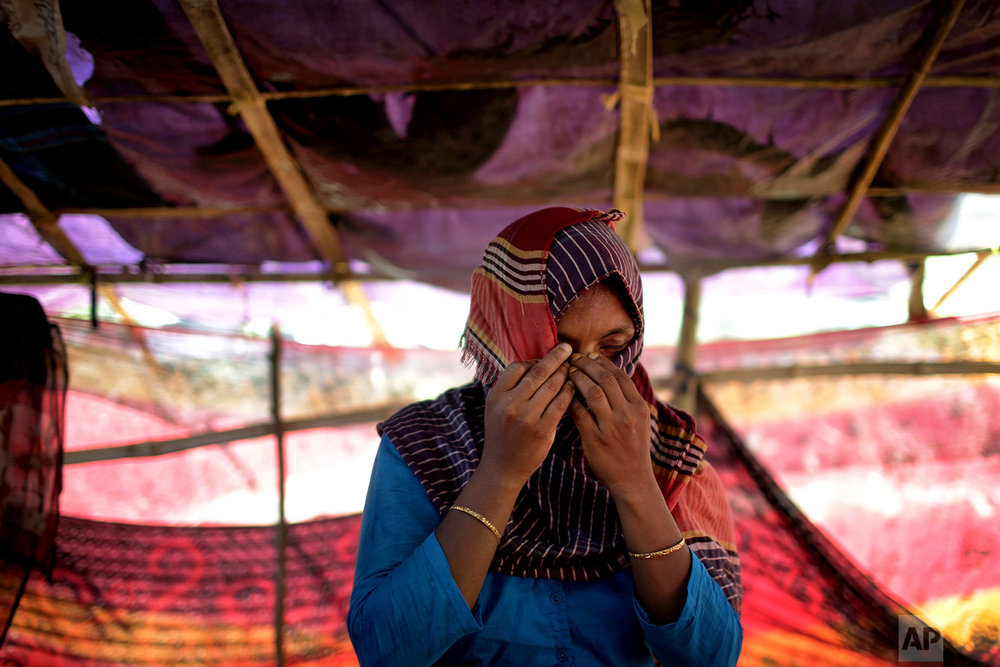  In this Monday, Nov. 20, 2017, photo, D, 30, mother of four where two of her sons are missing, who says she was raped by members of Myanmar's armed forces in late August, hides her face while she was being photographed in a friend's tent in Kutupalo