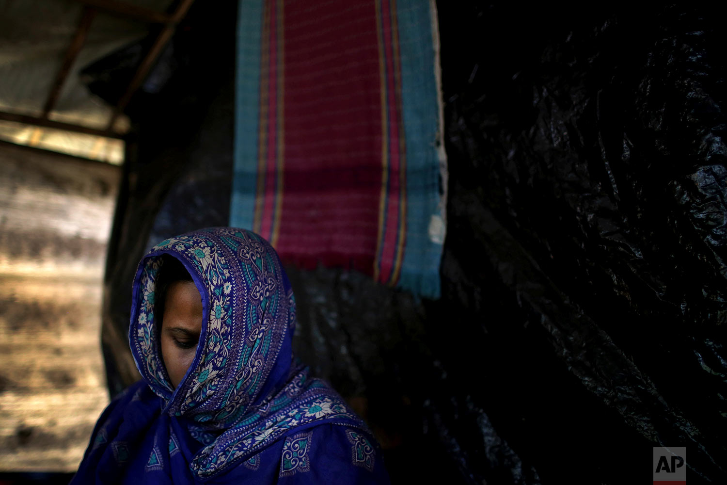  In this Monday, Nov. 20, 2017, photo, M, 35, mother of three, who says she was raped by members of Myanmar's armed forces in late August, is photographed in her friend's tent in Kutupalong refugee camp in Bangladesh.  (AP Photo/Wong Maye-E)

 