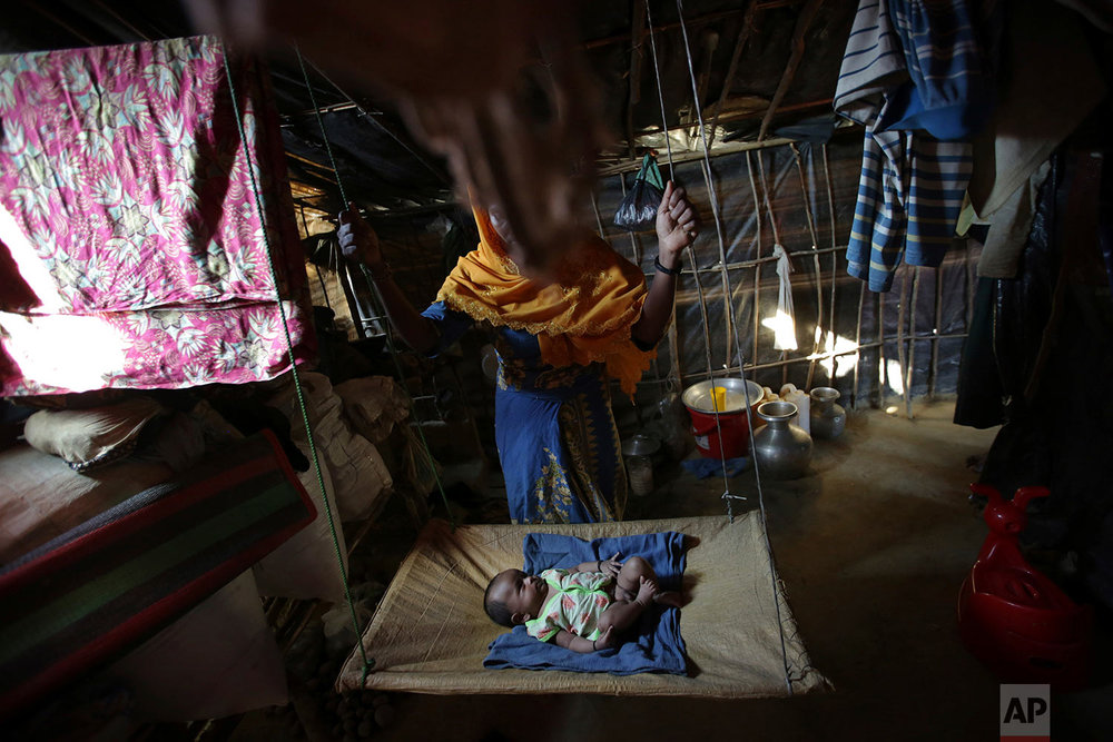  In this Sunday, Nov. 19, 2017, photo, K, 25, swings her two month old baby in her tent in Kutupalong refugee camp in Bangladesh. (AP Photo/Wong Maye-E) 