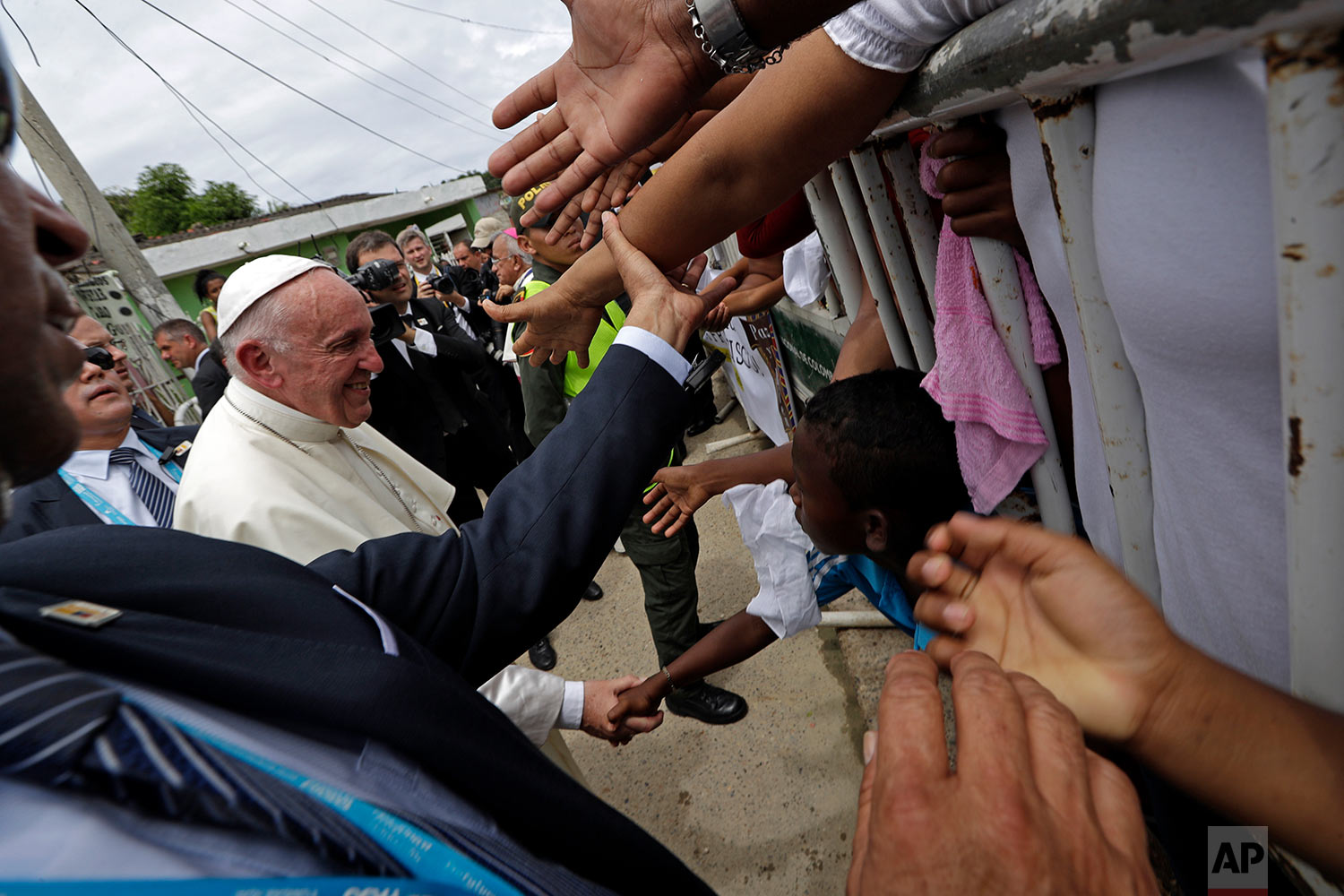 Pope Francis' greets people in the San Francisco neighborhood of Cartagena, Colombia, Sunday, Sept. 10, 2017. The Argentine pontiff is in the port city to honor St. Peter Claver, a 17th-century Jesuit who ministered to the tens of thousands of African slaves who arrived to be sold. (AP Photo/Andrew Medichini)