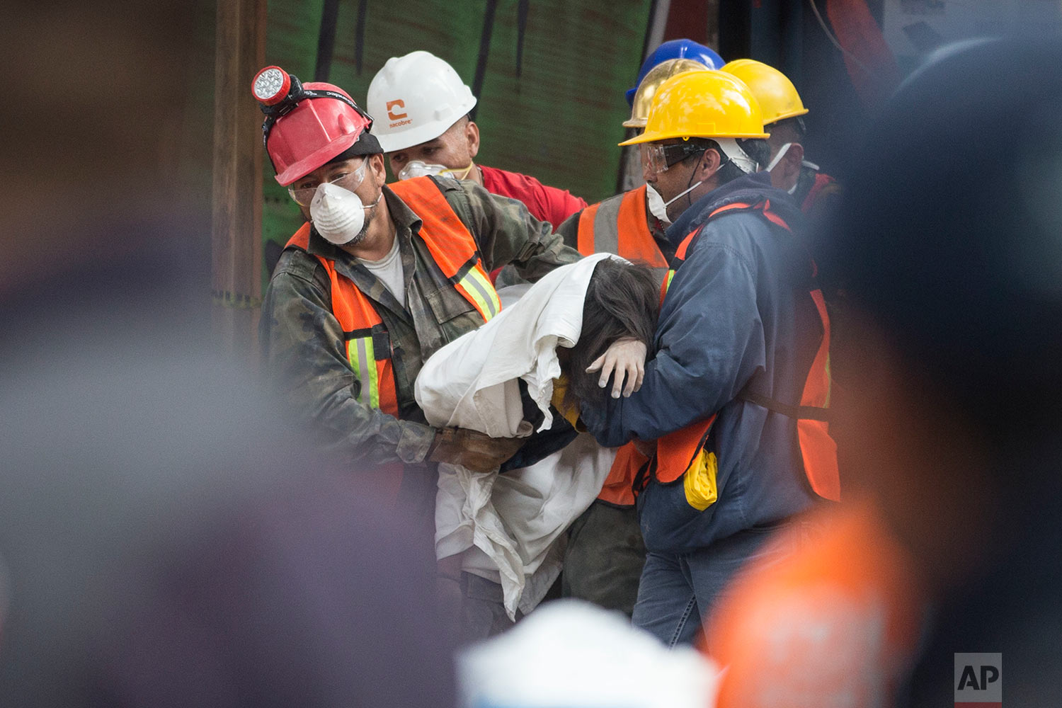 Rescue workers carry a body recovered from a building felled by a 7.1 magnitude earthquake in the Ciudad Jardin neighborhood of Mexico City, Thursday, Sept. 21, 2017, two days after the quake. Thousands worked frantically at dozens of wrecked buildings across the capital and nearby states looking for survivors of the powerful quake that killed 369 people. (AP Photo/Moises Castillo)