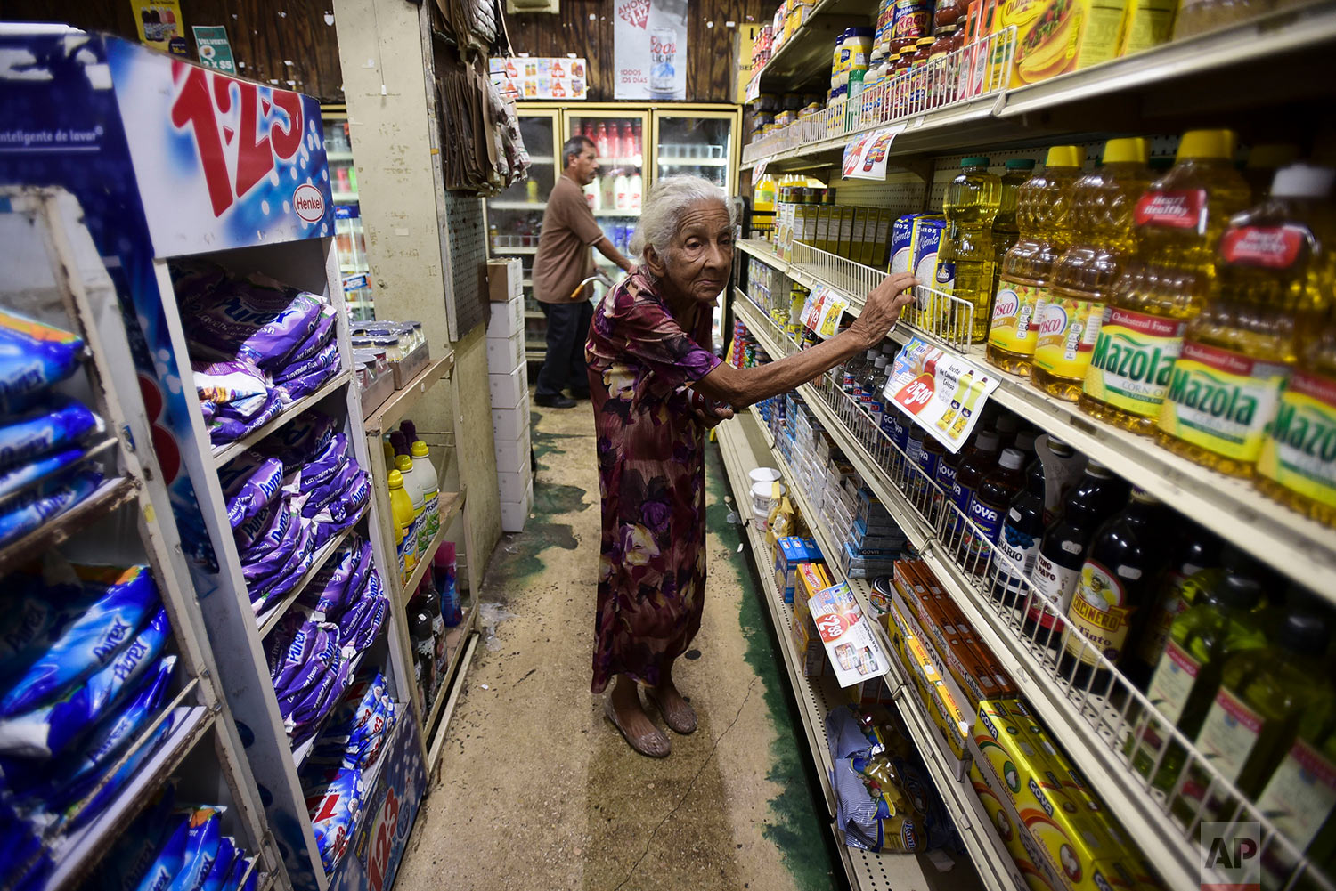 Residents from Juana Matos look for groceries at Catano Mini Market in the middle of a supply shortage caused by the passage of Hurricane Maria in Catano, Puerto Rico, Wednesday, Sept. 27, 2017. Since the devastating impact of the hurricane, the supply of goods has been interrupted in the US territory, causing endless lines in gas stations and comercial centers. (AP Photo/Carlos Giusti)