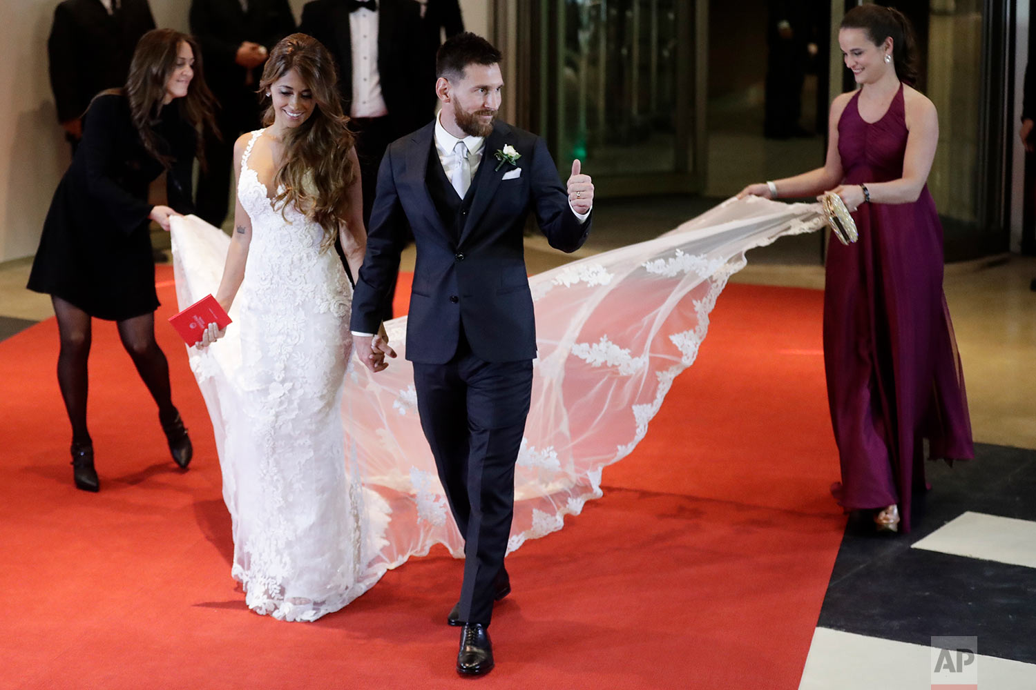 Newlywed Lionel Messi flashes a thumbs up as he and his bride Antonella Roccuzzo walk on a red carpet to pose for photographers after tying the knot in a civil ceremony in Rosario, Argentina, Friday, June 30, 2017. Guests including teammates and former teammates of the Barcelona star attended the highly anticipated ceremony. (AP Photo/Victor R. Caivano)