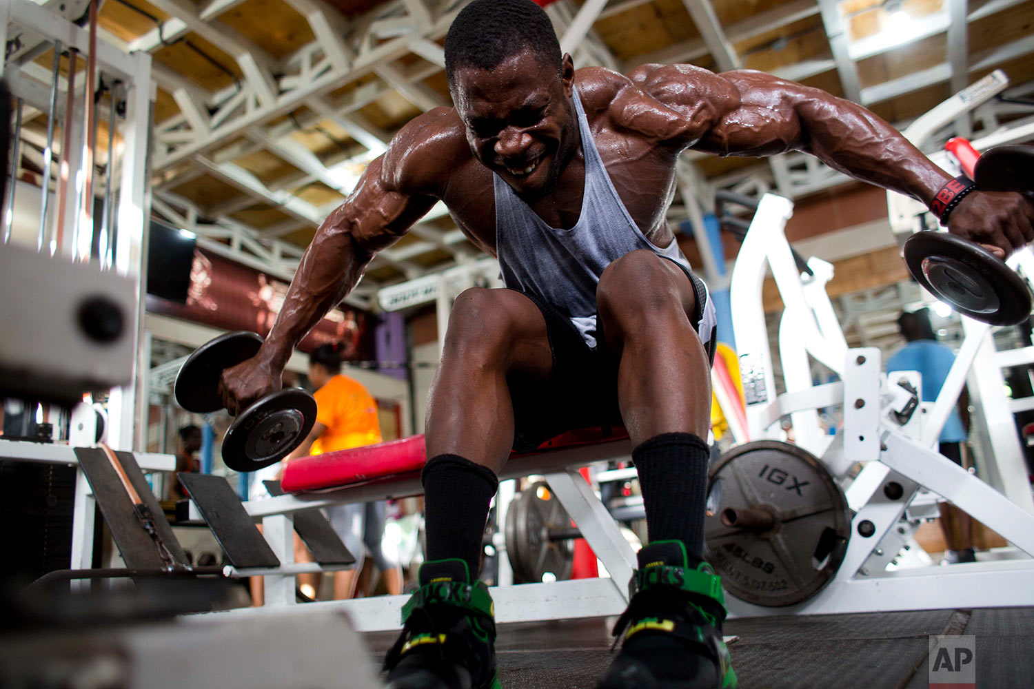 Bodybuilder Spely Laventure trains for an upcoming competition between Haiti and Dominican Republic in Port-au-Prince, Haiti, Thursday, July 20, 2017. Laventure could not find a coach when he began training, so he studied YouTube videos and followed bodybuilders on Instagram to learn about the sport and imitate workouts. (AP Photo/Dieu Nalio Chery)