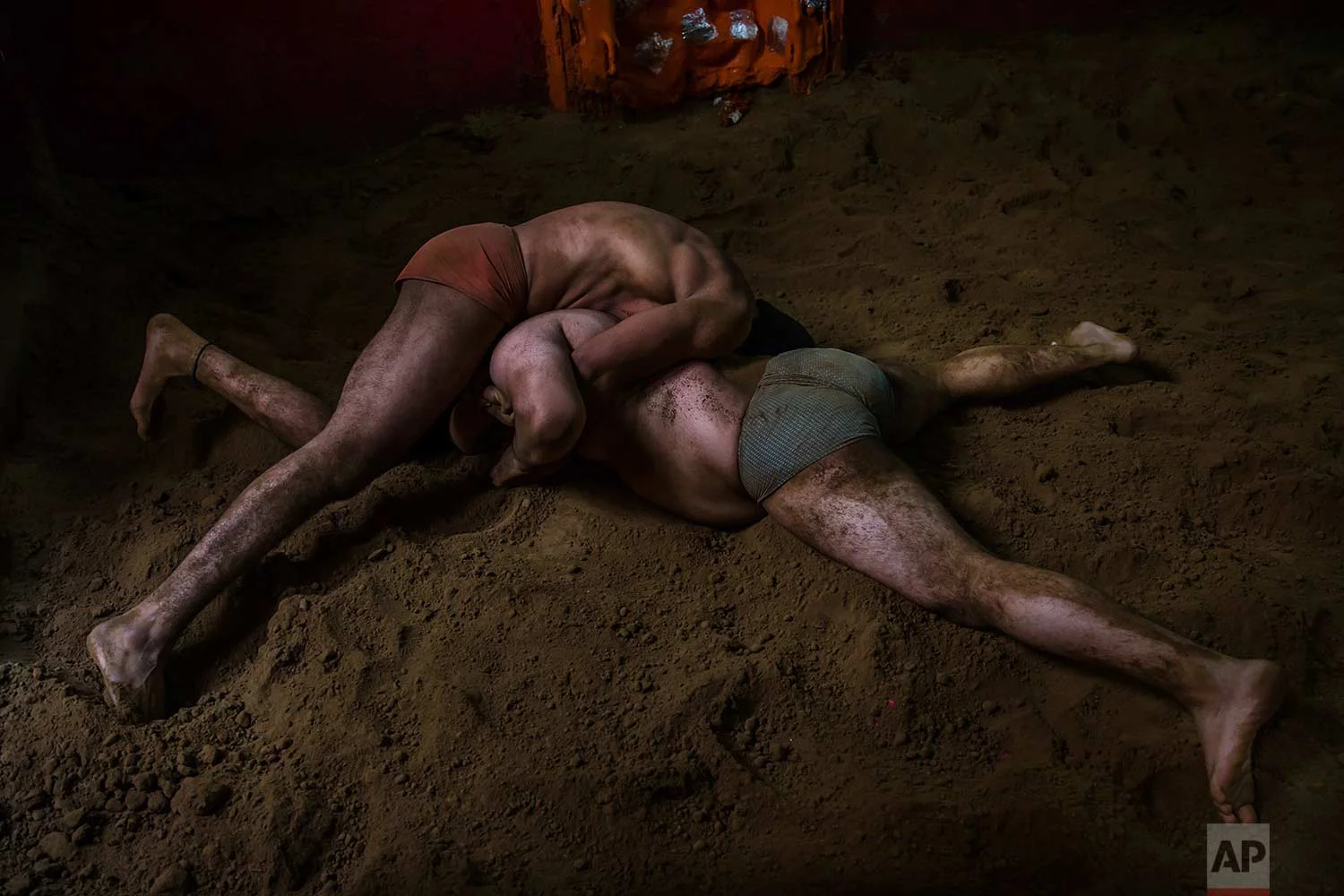 In this Nov. 20, 2017 photo, Indian kushti wrestlers fight in the ring, during their daily training at an akhada, a kind of wrestling hostel at Sabzi Mandi, in New Delhi, India. (AP Photo/Dar Yasin)