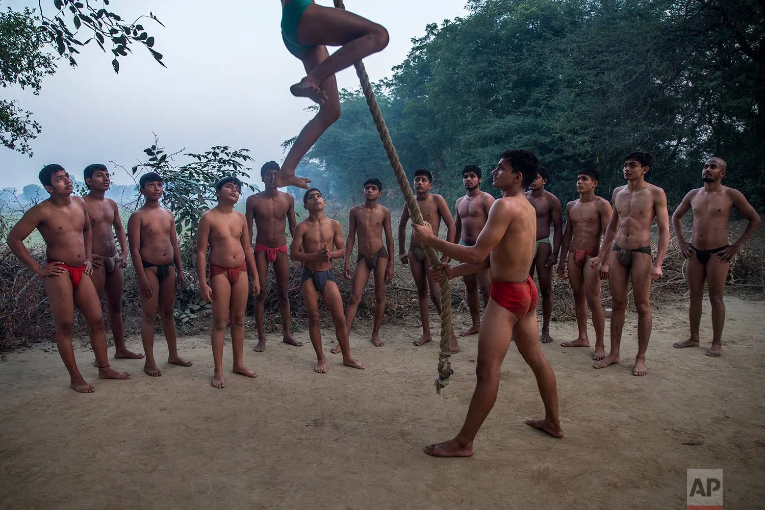 In this Nov. 22, 2017 photo, Indian Kushti wrestlers wait for their turn to practice rope climbing, during their daily training, at an akhada, a kind of wrestling hostel at Bahadurgarh, in Haryana, India. (AP Photo/Dar Yasin)
